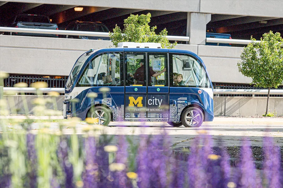 Action shot of an automously driven car passing in front of Michigan Law buildings