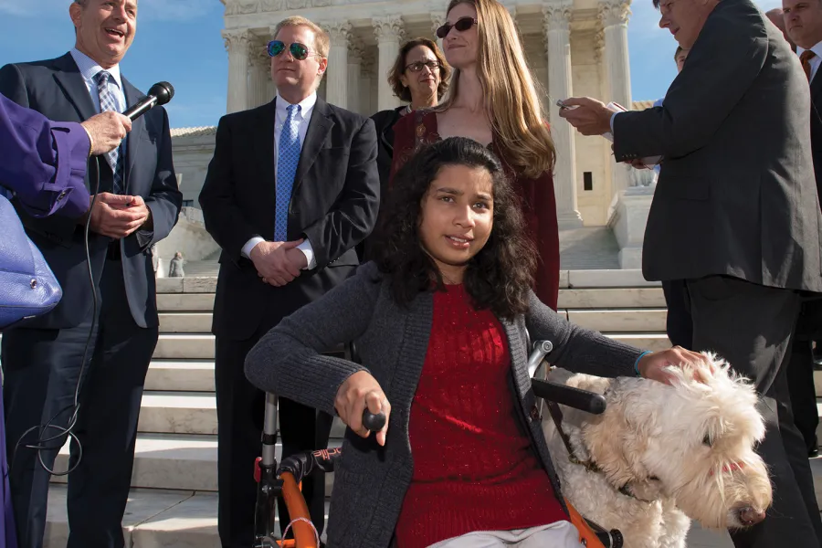 Ehlena with her dog fighting for disability rights on the steps of the Supreme Court.