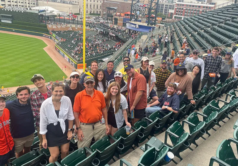 Professor Rich Friedman standing next to a group of students at Comerica Park.