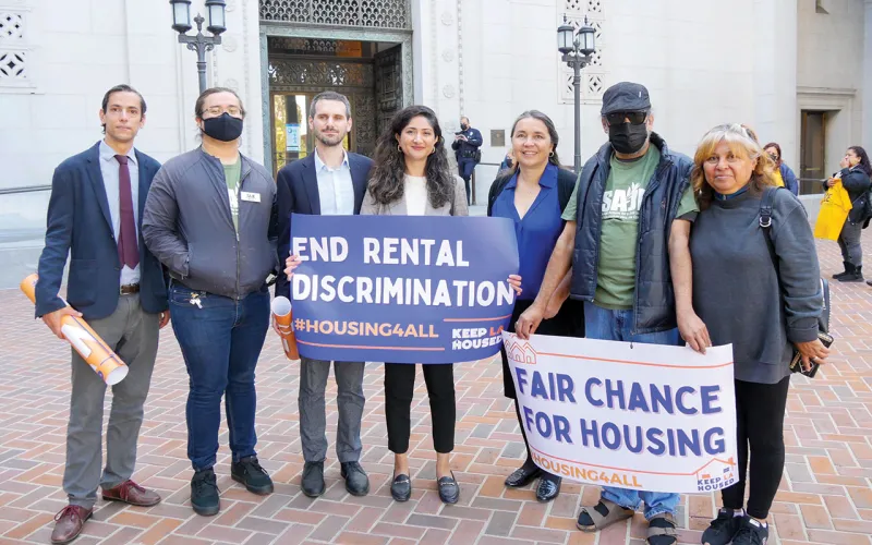 A group of people holding signs that read  "End Rental Discrimination" and "Fair Change for Housing".