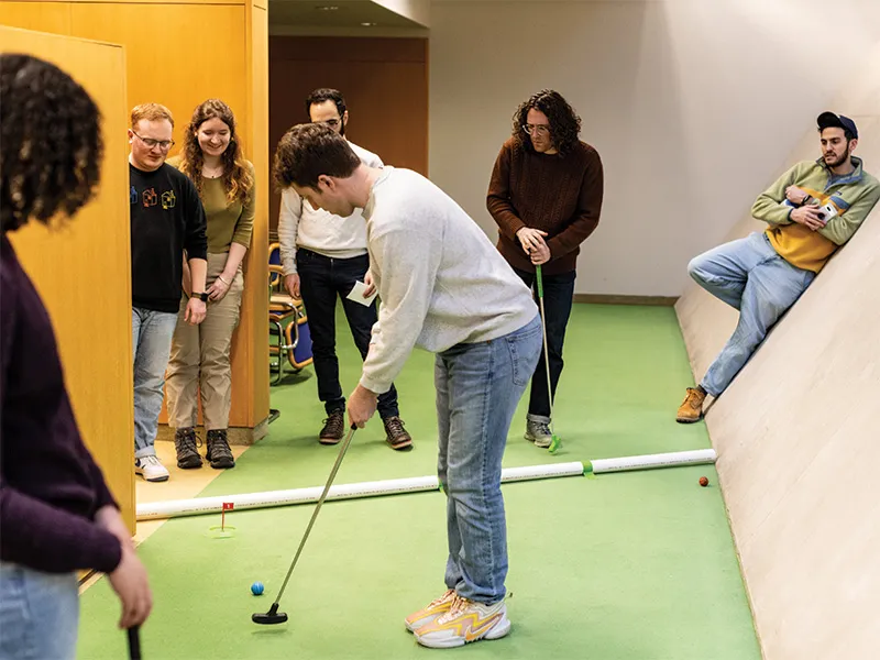 Michigan Law students playing mini golf in the Law Library subs