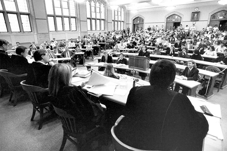 summer-2025-cover-gallery-bw-003.jpg A panel of judges are seated in front of a crowded classroom.