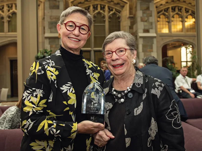 Lisa Tucker-Gray and Svea Gray accept the Distinguished Alumni Award on behalf of their father and husband, Professor Emeritus Whitmore Gray, ’57.