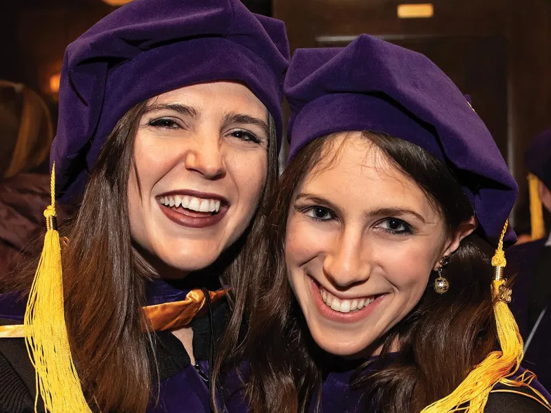 Two people smiling at their graduation celebration