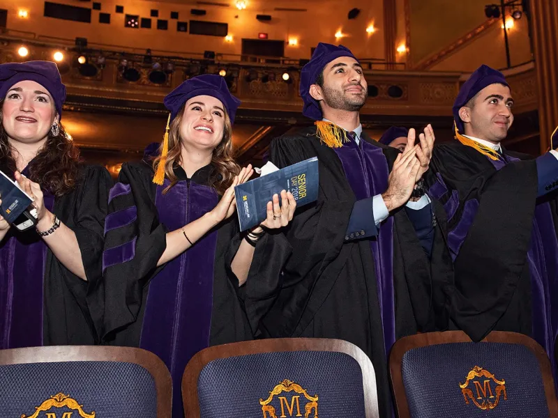 Group of graduates clapping at a speak 