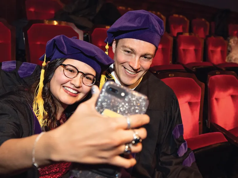 Two people taking a selfie at graduation