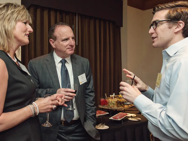 To alumni talking to an award recipient at a law school event