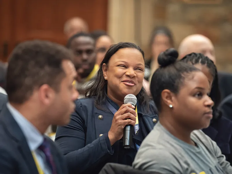 A person asking a question to the panel at UM BAR Reunion in the Quad 