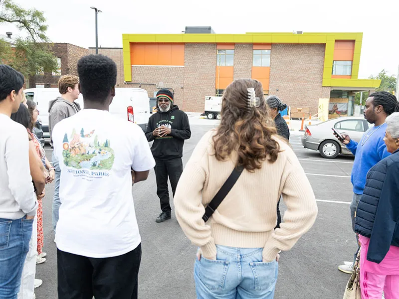 A person speaking in front of a group of students.