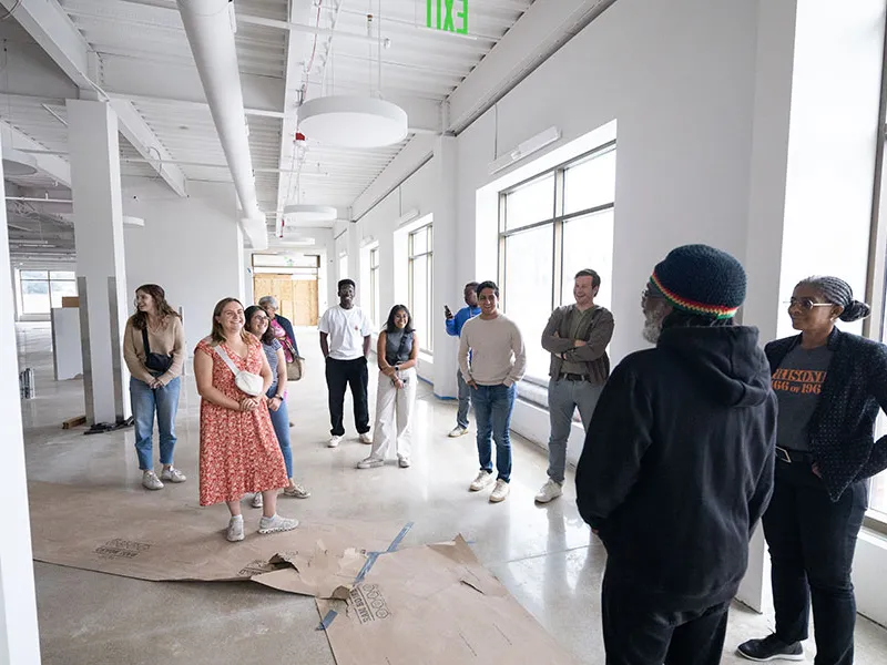 A person speaking to a group of students.