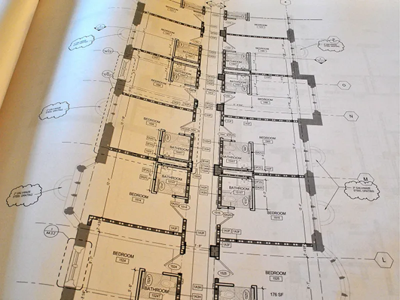 The Lawyers Club floor plan showing the rooms that will be erected in the empty demolished space in the background.