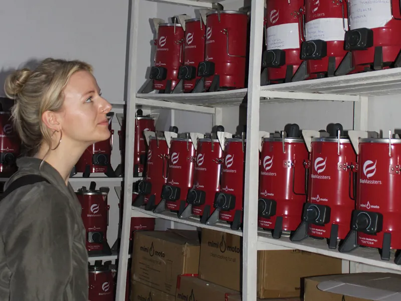 Clinic student Lindsey Corbett checks out BioMassters stoves in a storehouse in Kigali. The company produces inexpensive clean-cooking stoves as well as pellet fuel from recycled products for use in the stoves