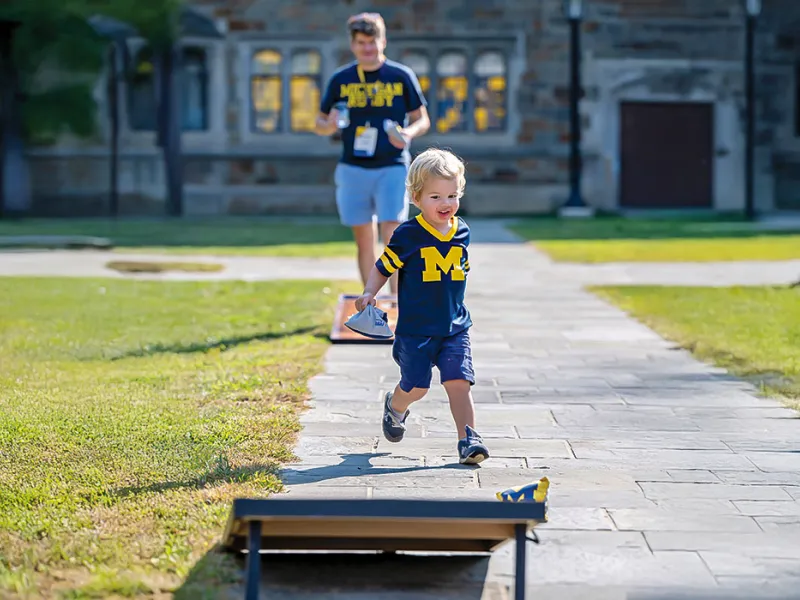 Michigan Law alumni and their child gather in the Law Quad for an alumni reunion.