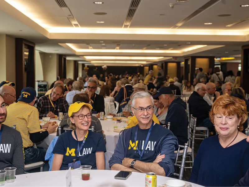A group of Michigan Law alumni gathered around a dining table.
