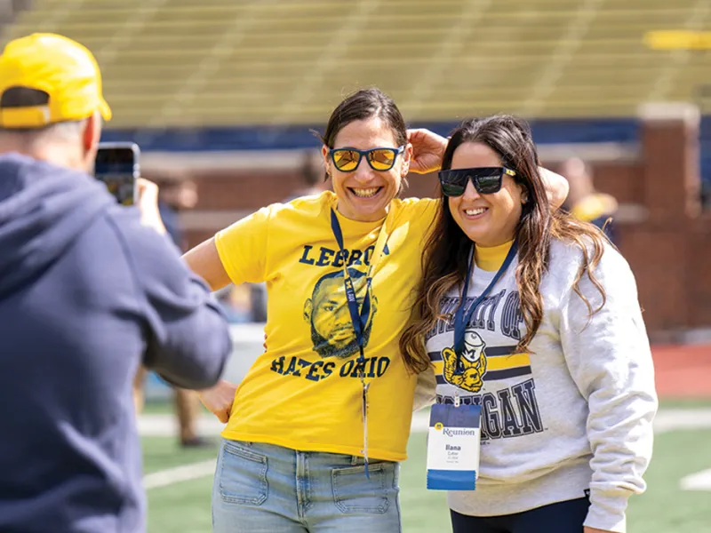 A group of Michigan Law alumni pose for a portrait being taken on a mobile phone