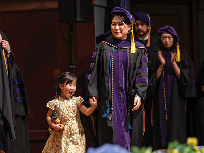 Michigan Law Student walks across stage with daughter.