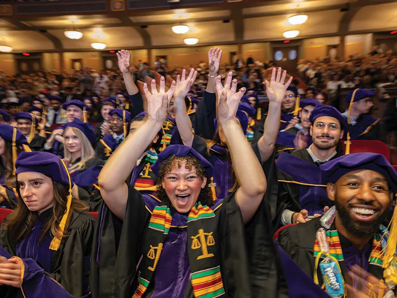 Michigan Law students cheering with their hands in the air.