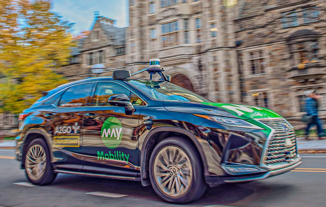 Action shot of an automously driven car passing in front of Michigan Law buildings