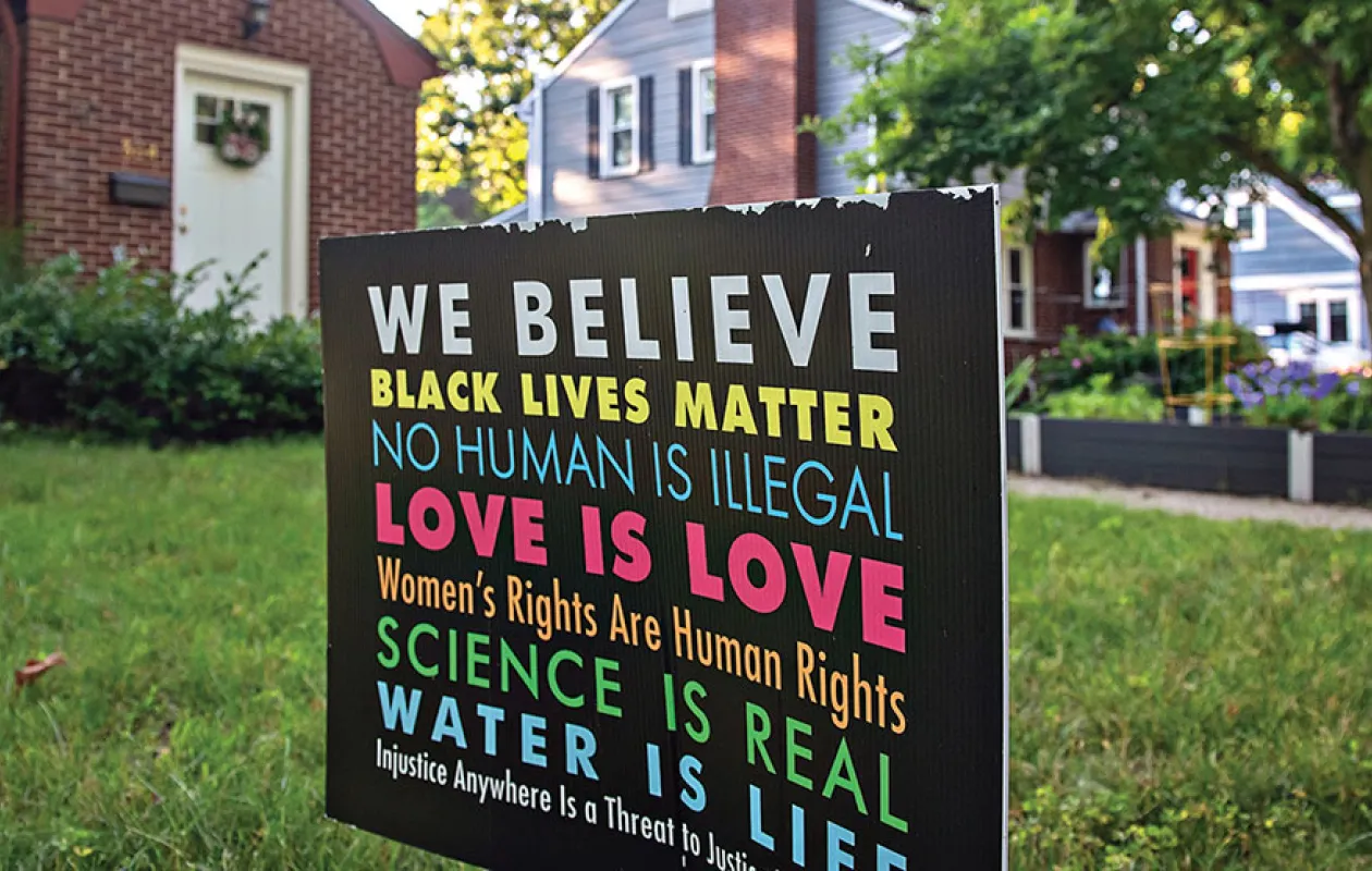 Sign in front of house that reads "We believe Black Lives Matter. No Human is Illegal. Love is Love. Women's Rights are Human Rights. Science is Real. Water is Life. Injustice Anywhere is a Threat to Justice Everywhere. 