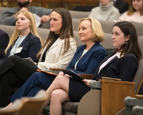 summer-2025-cover-feature-aside-003.jpg Four women seated side by side in an auditorium, looking toward the front of the room.