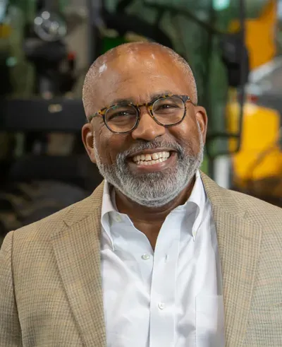 Marc Howze smiling in front of plant