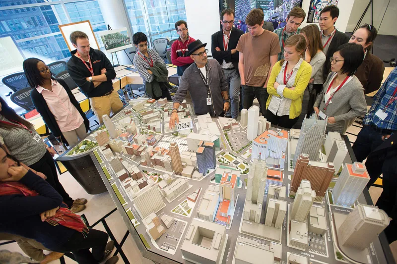 Bruce Schwartz, Detroit relocation ambassador, shows the students downtown Detroit in miniature at Quicken Loans. 