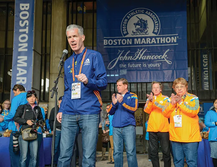 Tom Grilk, ’72, addresses runners and supporters at the 2014 Boston Marathon.