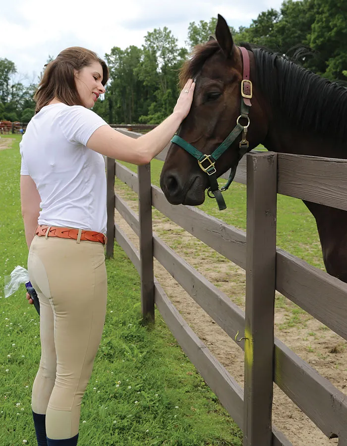 Mary Watkins, ’14, visits with one of the many horses cared for by Horses’ Haven, a nonprofit humane care and adoption agency for horses, ponies, and other animals in Howell, Michigan. 