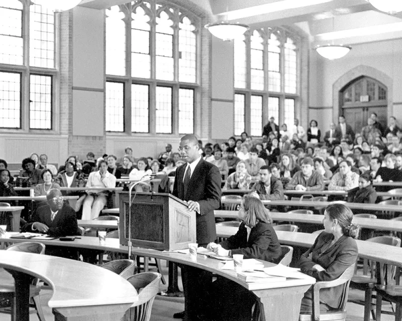 summer-2025-cover-feature-aside-015.jpg A man standing in a large auditorium at a podium.