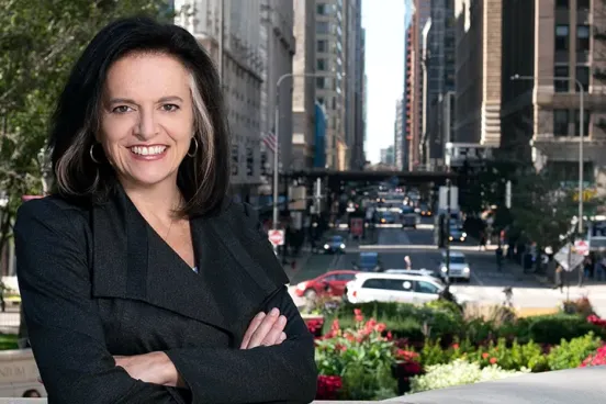 Linda Coberly posing in front of a busy downtown street