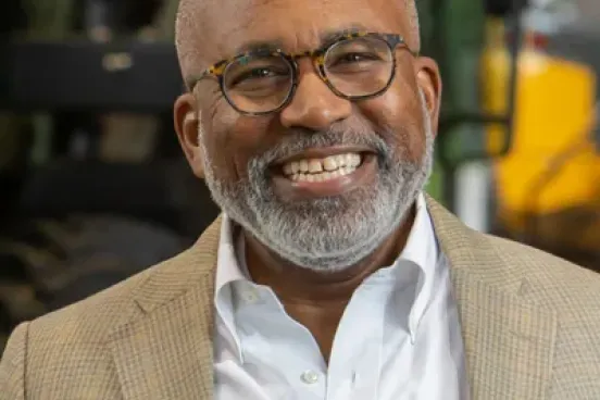 Marc Howze smiling in front of plant