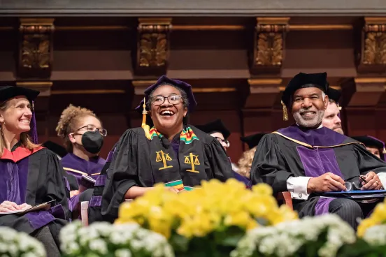 Hilary Allen, '22, (center) and the Hon. Roger Gregory, '78, (right) during the Senior Day ceremony at Hill Auditorium.