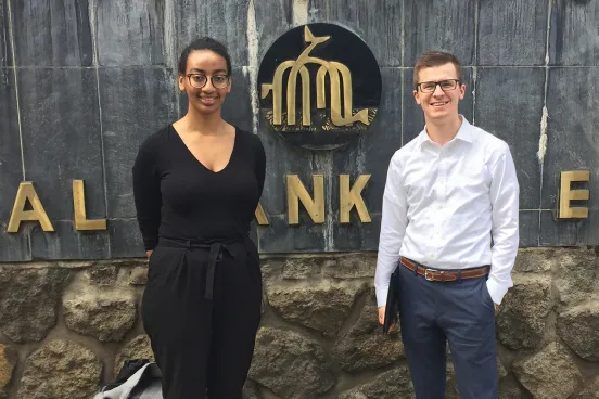  Two people standing in-front of a sign in Ethiopia. Left to right 2Ls Millan Bederu and Robert Shoemaker.