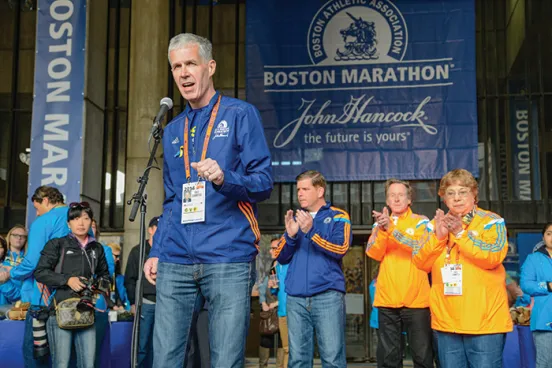 Tom Grilk, ’72, addresses runners and supporters at the 2014 Boston Marathon.