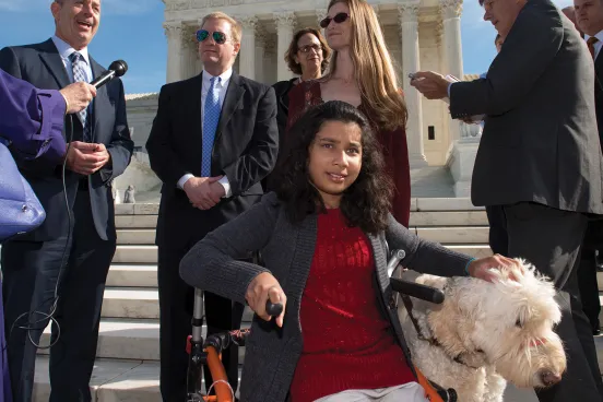 Ehlena with her dog fighting for disability rights on the steps of the Supreme Court.