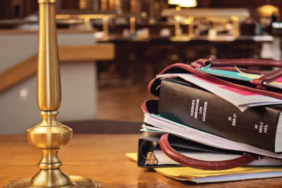 Image of a bag on a table with books and papers overflowing out of the bag