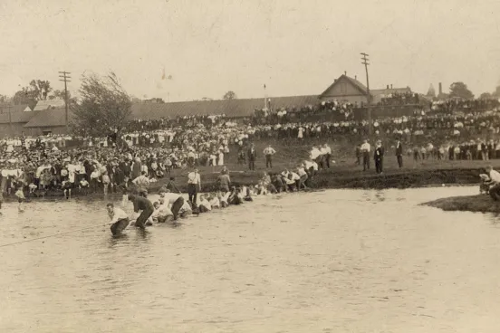 Students playing tug-of-war in a pond