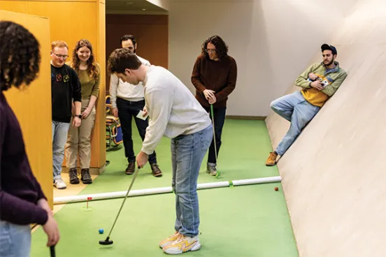 Michigan Law students playing mini golf in the Law Library subs