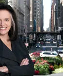 Linda Coberly posing in front of a busy downtown street