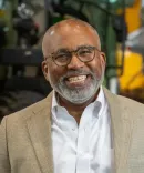 Marc Howze smiling in front of plant