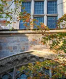 Beautiful image of the University of Michigan law school's architecture. There are trees starting to bloom in the foreground.