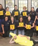 Michigan law student standing with individual letters that spell out: Thank you.