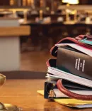 Image of a bag on a table with books and papers overflowing out of the bag