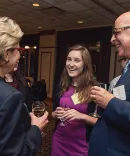 Two alumni talking to a law student at a law school event