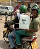 Two of Jibu's local entrepreneurs holding a container of water with Jibu logo