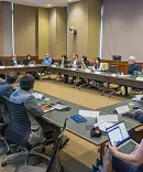 Conference participants sitting around a large table.