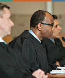 Judges at Michigan Law Three judges in black robes seated at a court bench, engaged in discussion, with microphones and papers in front of them.